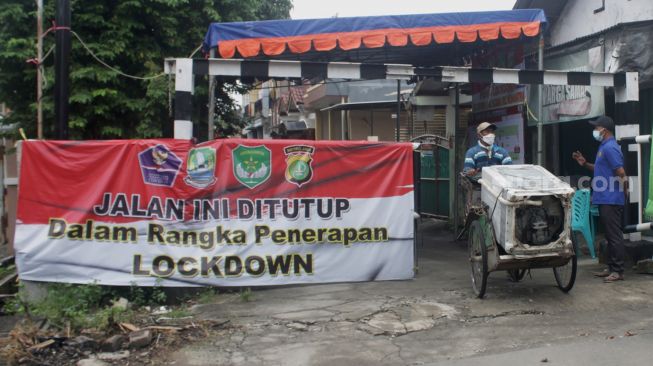 Suasana gerbang utama RT 02 di Kelurahan Pejuang, Kecamatan Medan Satria, Bekasi, Kamis (17/6/2021).  [Suara.com/Dian Latifah]
