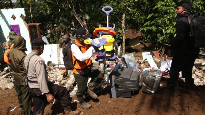 Petugas SAR gabungan mengevakuasi barang-barang yang masih bisa diselamatkan dari tumpukan material longsor di Pakel, Licin, Banyuwangi, Jawa Timur, Kamis(17/6/2021). ANTARA FOTO/Budi Candra Setya
