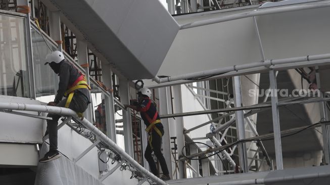 Pekerja menyelesaikan pembangunan halte Centrale Stichting Wederopbouw (CSW) di kawasan Kebayoran Baru, Jakarta, Kamis (17/6/2021). [Suara.com/Angga Budhiyanto]