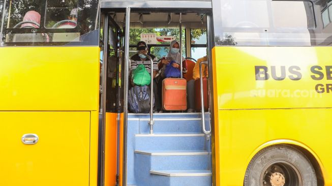 Para pasien Covid-19 menunggu didalam bus jemputan untuk dievakuasi ke RSDC Wisma Atlet di Puskesmas Lubang Buaya, Jakarta Timur, Jumat (18/6/2021). [Suara.com/Alfian Winanto]