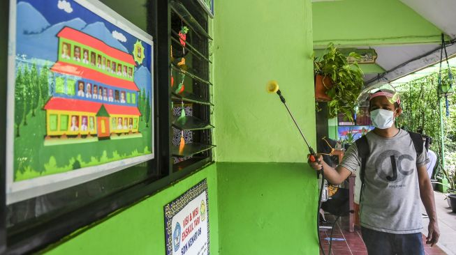 Petugas menyemprotkan disinfektan di ruang kelas SD Kenari 08 Pagi, Jakarta, Jumat (18/6/2021).  ANTARA FOTO/Galih Pradipta