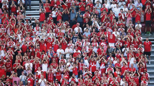 Suporter Denmark membentangkan spanduk dukungan untuk Christian Eriksen saat laga Piala Eropa 2020 Grup B antara Denmark melawan Belgia di Parken Stadium, Copenhagen, Kamis (17/6/2021).  [AFP/Photo]