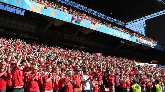 Suporter Denmark membentangkan spanduk dukungan untuk Christian Eriksen saat laga Piala Eropa 2020 Grup B antara Denmark melawan Belgia di Parken Stadium, Copenhagen, Kamis (17/6/2021).  [AFP/Photo]