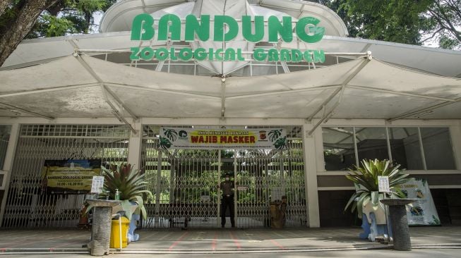 Petugas keamanan berjaga di depan gerbang Kebun Binatang Bandung Zoological Garden, Bandung, Jawa Barat, Jumat (18/6/2021). ANTARA FOTO/Novrian Arbi