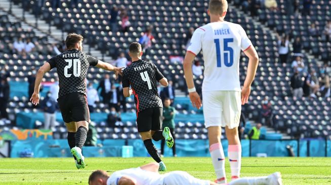 Pemain depan Kroasia Ivan Perisic diberi ucapan selamat oleh teman satu tim karena mencetak gol pertama mereka selama pertandingan sepak bola Grup D EURO 2020 antara Kroasia melawan Republik Ceko di Hampden Park di Glasgow, Jumat (18/6/2021). [AFP/Photo]