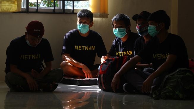 Sejumlah pelaku penangkapan ikan ilegal berkewarganegaraan Vietnam beristirahat di aula Kantor Imigrasi Kelas I TPI Pontianak di Pontianak, Kalimantan Barat, Sabtu (19/6/2021).  ANTARA FOTO/Jessica Helena Wuysang