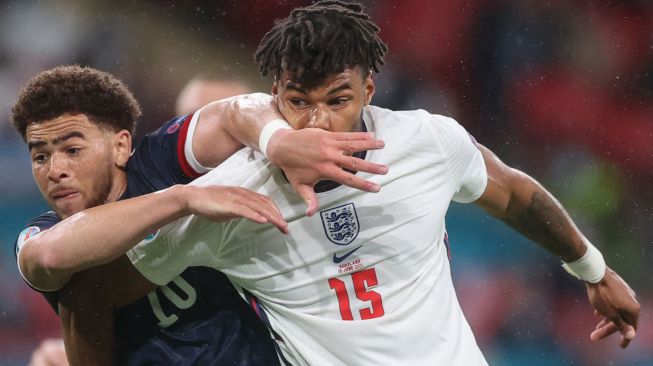 Penyerang Skotlandia Che Adams (kiri) berebut bola dengan bek Inggris Tyrone Mings  selama pertandingan sepak bola Grup D EURO 2020 antara Inggris melawan Skotlandia di Stadion Wembley di London, Inggris, Sbatu (19/6) dini hari WIB. CARL RECINE / KOLAM RENANG / AFP
