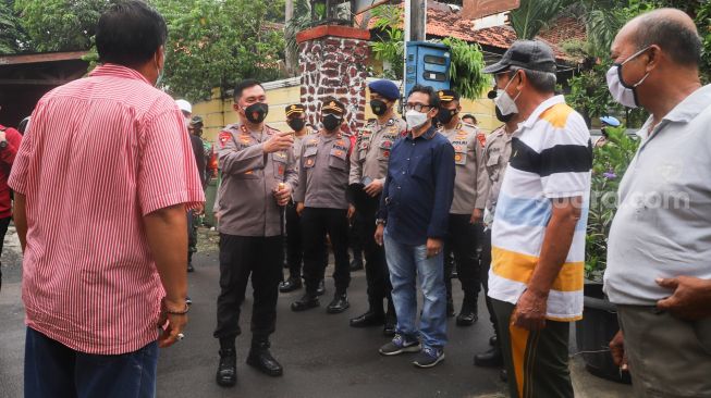 Kapolda Metro Jaya Irjen Fadil Imran (tengah) menyapa warga saat melakukan kunjungan ke Kampung Tangguh Jaya RW 13 Bidara Cina, Jakarta Timur, Sabtu (19/6/2021). [Suara.com/Alfian Winanto]