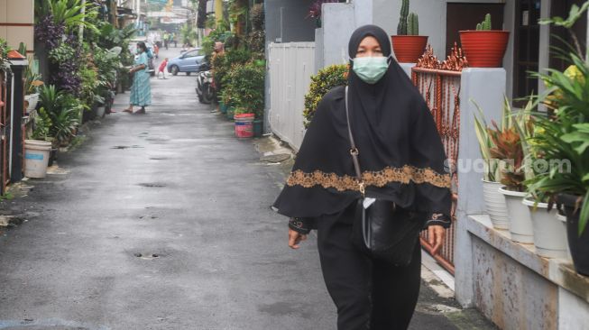 Warga beraktivitas dengan menggunakan masker di Kampung Tangguh Jaya RW 13 Bidara Cina, Jakarta Timur, Sabtu (19/6/2021). [Suara.com/Alfian Winanto]