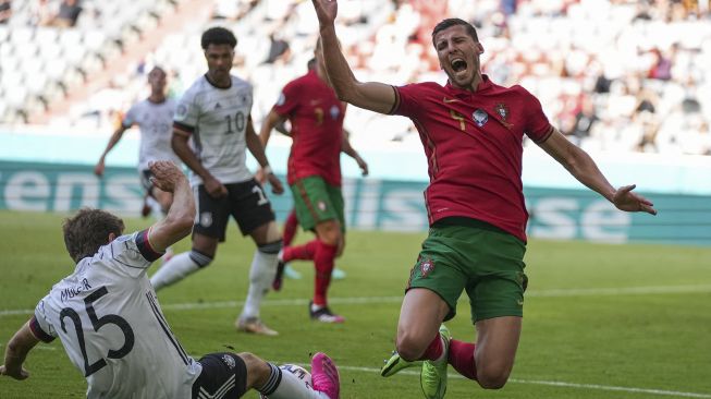 Bek Portugal Ruben Dias (kanan) berbenturan dengan pemain depan Jerman Thomas Mueller (kiri) selama pertandingan sepak bola Grup F UEFA EURO 2020 antara Portugal dan Jerman di Allianz Arena, Munich pada (19/6/2021). [Matthias Schrader / POOL / AFP]