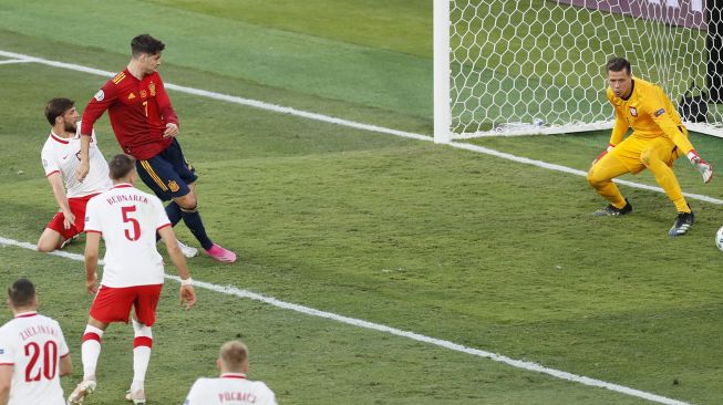 Pemain Spanyol Alvaro Morata (tengah) melakukan tendangan untuk mencetak gol pembuka pada pertandingan sepak bola Grup E UEFA EURO 2020 antara Spanyol dan Polandia di Stadion La Cartuja, Seville, Spanyol, pada (19/6/2021). [Jose Manuel Vidal / POOL / AFP]