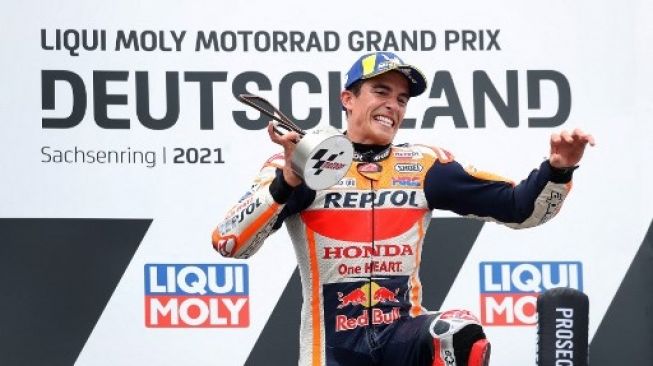 Rider Repsol Honda Marc Marquez melakukan selebrasi di podium setelah menjadi juara di MotoGP Jerman 2021 di sirkuit Sachsenring. Ronny HARTMANN / AFP