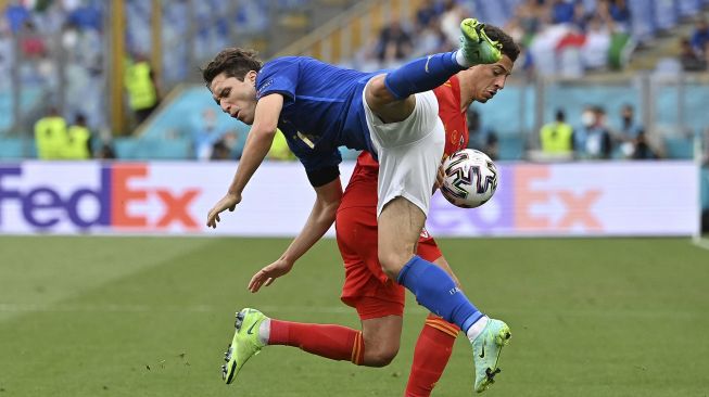 Bek Wales Ethan Ampadu (belakang) berebut bola dengan gelandang Italia Federico Chiesa selama pertandingan sepak bola Grup A UEFA EURO 2020 antara Italia dan Wales di Stadion Olimpiade, Roma, pada (20/6/2021). [ANDREAS SOLARO / POOL / AFP]