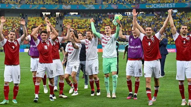 Para pemain Austria bersama para staf merayakan kepastian timnya lolos 16 besar Euro 2020 di National Arena, Senin (21/6/2021).  [Foto/AFP]