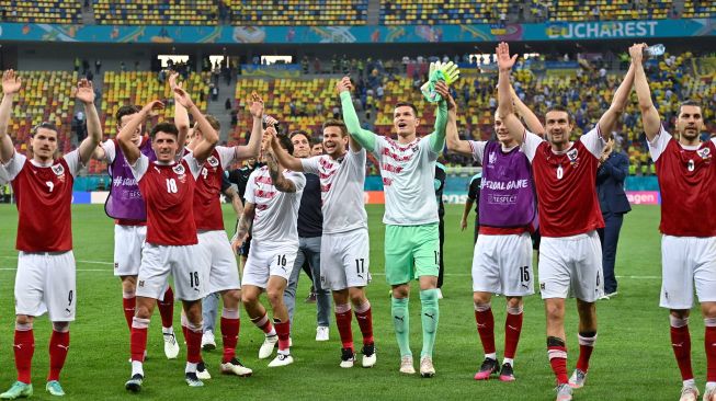 Para pemain Austria bersama para staf merayakan kepastian timnya lolos 16 besar Euro 2020 di National Arena, Senin (21/6/2021).  [Foto/AFP]