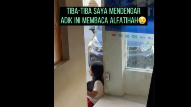 Bocah membaca Alfatihah di depan bilik ATM. (Instagram/memomedsos)