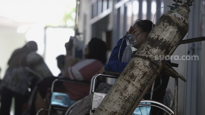 Pasien COVID-19 memakai alat bantu oksigen menunggu untuk mendapatkan tempat tidur perawatan di IGD RSUD Cengkareng, Jakarta, Rabu (23/6/2021). [Suara.com/Angga Budhiyanto]
