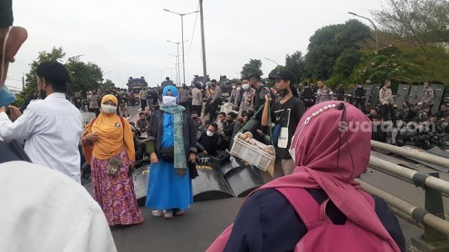 Sebelum Bubar Jalan, Emak-emak Simpatisan Rizieq Berfoto Ria di Depan Polisi Kelelahan