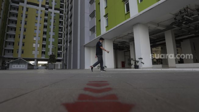 Seorang warga berjalan di kompleks Rumah Susun (Rusun) Pasar Rumput, Jakarta, Jumat (25/6/2021). [Suara.com/Angga Budhiyanto]