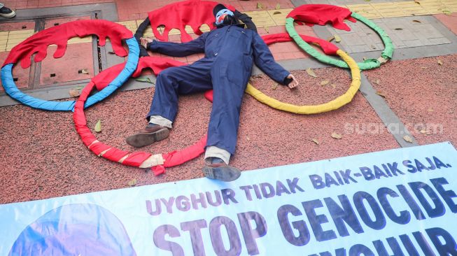 Massa koalisi Indonesia Save Uyghur melakukan pertunjukan teatrikal saat aksi damai di depan gedung Kemenpora, Jakarta Pusat, Jumat (25/6/2021). [Suara.com/Alfian Winanto]