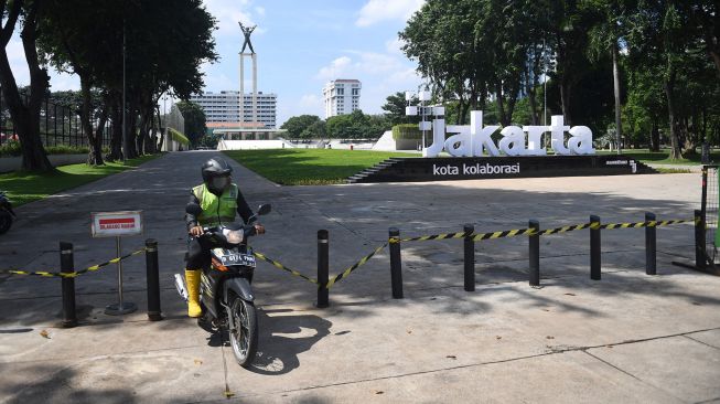Petugas berkendara keluar dari Taman Lapangan Banteng yang ditutup untuk sementara waktu di Jakarta, Jumat (25/6/2021). ANTARA FOTO/Akbar Nugroho Gumay