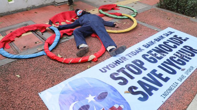 Massa koalisi Indonesia Save Uyghur melakukan pertunjukan teatrikal saat aksi damai di depan gedung Kemenpora, Jakarta Pusat, Jumat (25/6/2021). [Suara.com/Alfian Winanto]