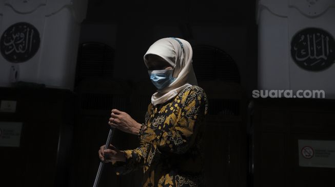 Petugas membersihkan bagian dalam Masjid Cut Meutia, Jakarta, Jumat (25/6/2021). [Suara.com/Angga Budhiyanto]