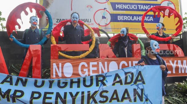 Massa koalisi Indonesia Save Uyghur saat menggelar aksi damai di depan gedung Kemenpora, Jakarta Pusat, Jumat (25/6/2021). [Suara.com/Alfian Winanto]