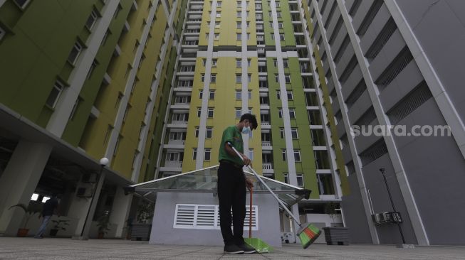 Petugas kebersihan menyapu salah satu bagian Rumah Susun (Rusun) Pasar Rumput, Jakarta, Jumat (25/6/2021). [Suara.com/Angga Budhiyanto]