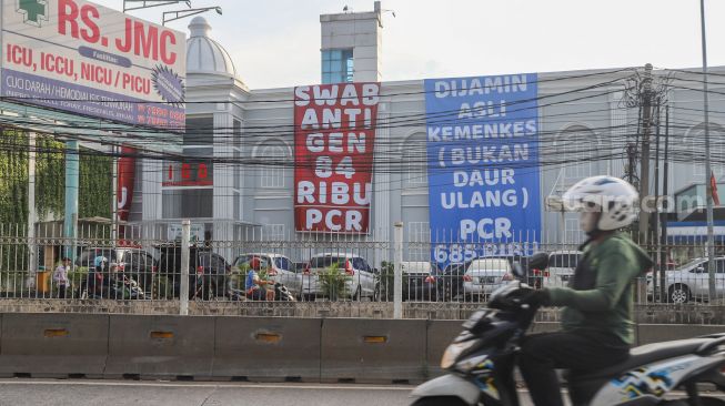 Spanduk besar mempromosikan harga tes swab antigen dan PCR ramai terpampang di kawasan Warung Buncit, Jakarta Selatan, Sabtu (26/6/2021). [Suara.com/Alfian Winanto]