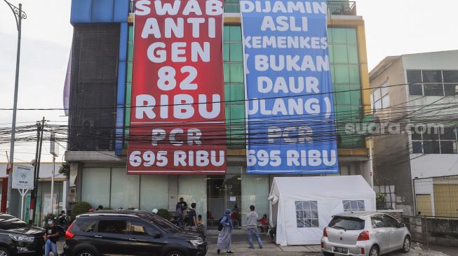 Spanduk besar mempromosikan harga tes swab antigen dan PCR ramai terpampang di kawasan Warung Buncit, Jakarta Selatan, Sabtu (26/6/2021). [Suara.com/Alfian Winanto]