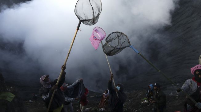 Warga menunggu sesaji yang dilemparkan ke kawah pada upacara ritual Yadnya Kasada di Gunung Bromo, Tengger, Probolinggo, Jawa Timur, Sabtu (26/6/2021). [ANTARA FOTO/Budi Candra Setya]