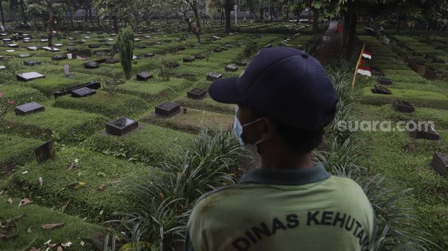 Petugas berada di Tempat Pemakaman Umum (TPU) Karet Bivak, Jakarta, Minggu (27/6/2021). [Suara.com/Angga Budhiyanto]