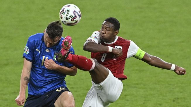 Gelandang Italia Bryan Cristante (kiri) dan bek Austria David Alaba berebut bola selama perpanjangan waktu dalam pertandingan sepak bola babak 16 besar UEFA EURO 2020 antara Italia dan Austria di Stadion Wembley, London, pada (26/6/2021). [JUSTIN TALLIS / POOL / AFP]