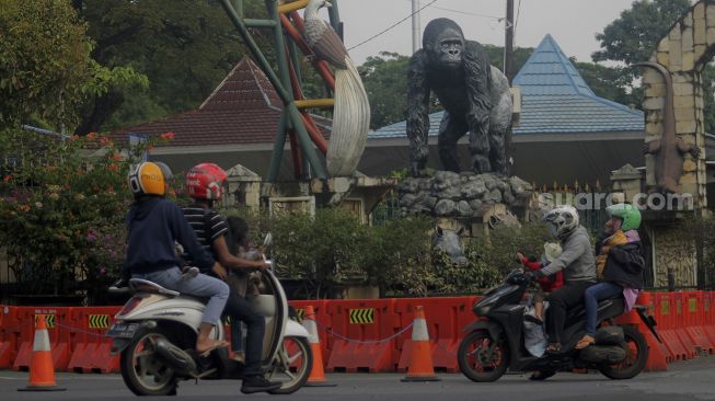 Calon pengunjung berada di depan gerbang utama Taman Margasatwa Ragunan, Jakarta, Minggu (27/6/2021). [Suara.com/Dian Latifah]