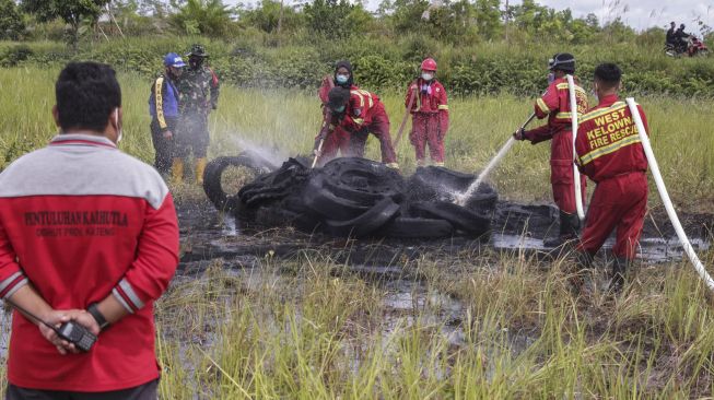 Relawan pelajar yang tergabung dalam komunitas Youth Act Kalimantan mempraktikkan cara pendinginan lahan gambut yang terbakar saat mengikuti pelatihan penanganan kebakaran hutan dan lahan (karhutla), Palangkaraya, Kalimantan Tengah, Minggu (27/6/2021). [ANTARA FOTO/Makna Zaezar]