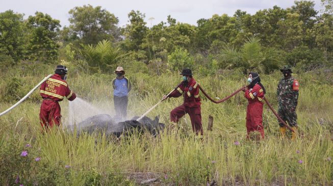 Relawan pelajar yang tergabung dalam komunitas Youth Act Kalimantan mempraktikkan cara pendinginan lahan gambut yang terbakar saat mengikuti pelatihan penanganan kebakaran hutan dan lahan (karhutla), Palangkaraya, Kalimantan Tengah, Minggu (27/6/2021). [ANTARA FOTO/Makna Zaezar]