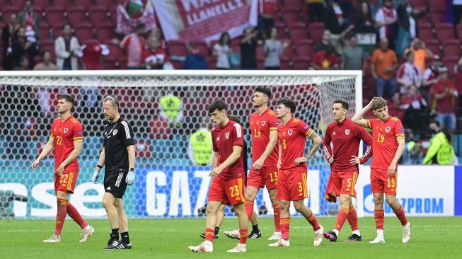 Para pemain Wales meninggalkan lapangan pada akhir pertandingan sepak bola babak 16 besar UEFA EURO 2020 antara Wales dan Denmark di Johan Cruyff Arena, Amsterdam, pada (26/6/2021). [Olaf Kraak / POOL / AFP]