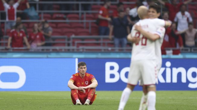 Bek Wales Joe Rodon bereaksi pada akhir pertandingan sepak bola babak 16 besar UEFA EURO 2020 antara Wales dan Denmark di Johan Cruyff Arena, Amsterdam, pada (26/6/2021). [Kenzo Tribouillard / POOL / AFP]