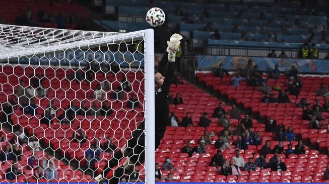 Penjaga gawang Austria Daniel Bachmann menyelamatkan tendangan bebas saat perpanjangan waktu dalam pertandingan sepak bola babak 16 besar UEFA EURO 2020 antara Italia dan Austria di Stadion Wembley, London, pada (26/6/2021). [Ben STANSALL / POOL / AFP]