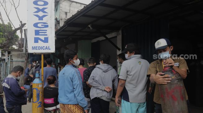 Sejumlah warga mengantre untuk mengisi ulang tabung oksigen di salah satu depot pengisian oksigen di kawasan Manggarai, Jakarta, Senin (28/6/2021). [Suara.com/Angga Budhiyanto]