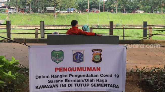 Warga mengunjungi kawasan Banjir Kanal Timur (BKT), Jakarta Timur, Senin (28/6/2021). [Suara.com/Alfian Winanto]