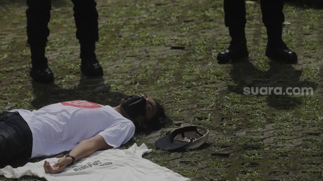 Massa aksi yang tergabung dalam serikat buruh dan masyarakat sipil melakukan aksi teatrikal di depan Gedung Merah Putih KPK, Jakarta, Senin (28/6/2021). [Suara.com/Angga Budhiyanto]