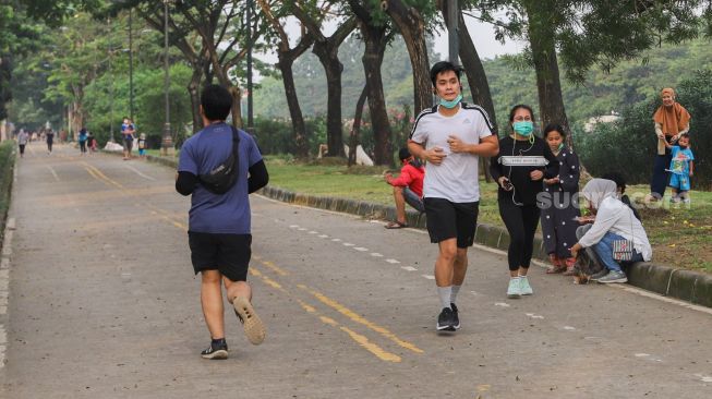 Warga berolahraga di kawasan Banjir Kanal Timur (BKT), Jakarta Timur, Senin (28/6/2021). [Suara.com/Alfian Winanto]