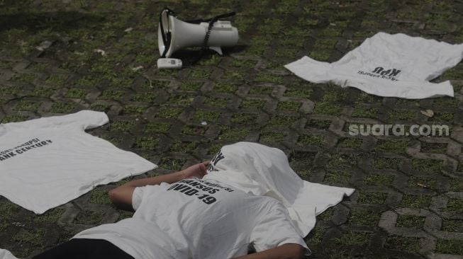 Massa aksi yang tergabung dalam serikat buruh dan masyarakat sipil melakukan aksi teatrikal di depan Gedung Merah Putih KPK, Jakarta, Senin (28/6/2021). [Suara.com/Angga Budhiyanto]