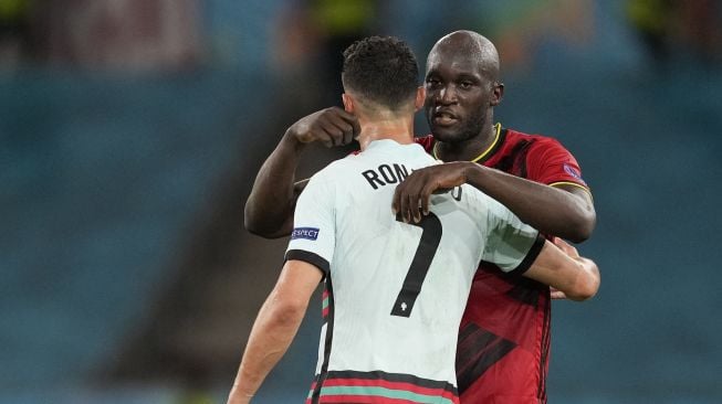 Penyerang Timnas Belgia, Romelu Lukaku (kanan) memeluk penyerang Timnas Portugal, Cristiano Ronaldo usai pertandingan 16 besar Euro 2020 di Sevilla, Spanyol, Senin (28/6/2021) dini hari WIB. [AFP/Photo]