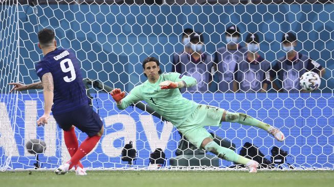 Pemain depan Prancis Olivier Giroud (kiri) mencetak penalti melewati kiper Swiss Yann Sommer selama pertandingan sepak bola babak 16 besar UEFA EURO 2020 antara Prancis dan Swiss di National Arena, Bucharest, pada (28/6/2021). [FRANCK FIFE / POOL / AFP]