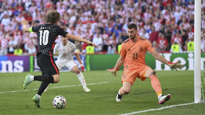 Penjaga gawang Spanyol Unai Simon (kanan) bersiap untuk memblok tembakan ke gawang oleh gelandang Kroasia Luka Modric selama pertandingan sepak bola babak 16 besar UEFA EURO 2020 antara Kroasia dan Spanyol di Stadion Parken, Kopenhagen, pada (28/6/2021). [STUART FRANKLIN / POOL / AFP]