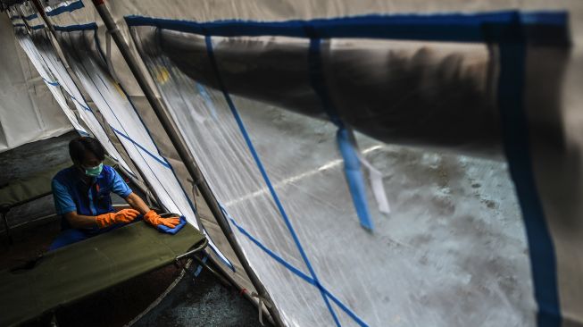 Karyawan Rumah Sakit Umum Daerah (RSUD) Tarakan menyiapkan velbed di dalam tenda darurat yang didirikan di halaman SDN 2 Cideng, Jakarta, Selasa (29/6/2021). [ANTARA FOTO/M Risyal Hidayat]