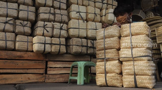 Pedagang menata besek dari anyaman bambu di Pasar Jatinegara, Jakarta, Rabu (30/6/2021). [Suara.com/Angga Budhiyanto]